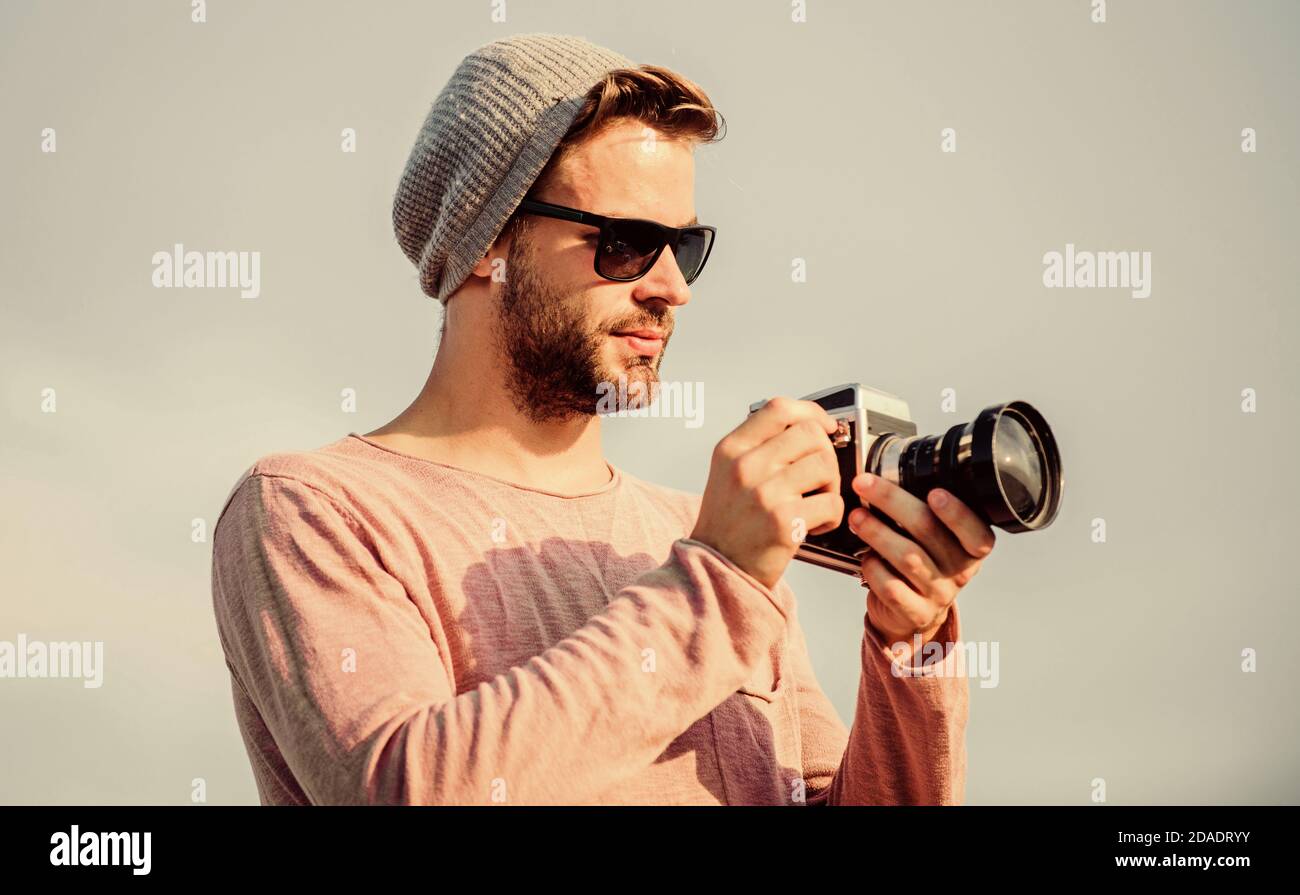 Fotografo professionista. Bel fotografo macchina fotografica retro. Concetto di fotogiornalista. Guy fotografo all'aperto cielo sfondo. Hipster reporter scattare foto. Impostazioni manuali. Blogger da viaggio. Foto Stock