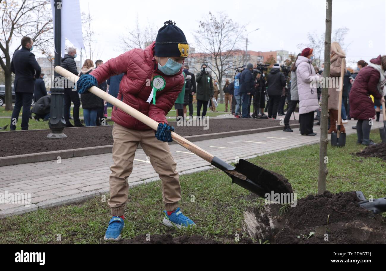 Non esclusivo: KIEV, UCRAINA - 11 NOVEMBRE 2020 - UN bambino tiene una vanga durante la cerimonia di piantagione di alberi in Piazza Ankara come parte del respiro per Foto Stock