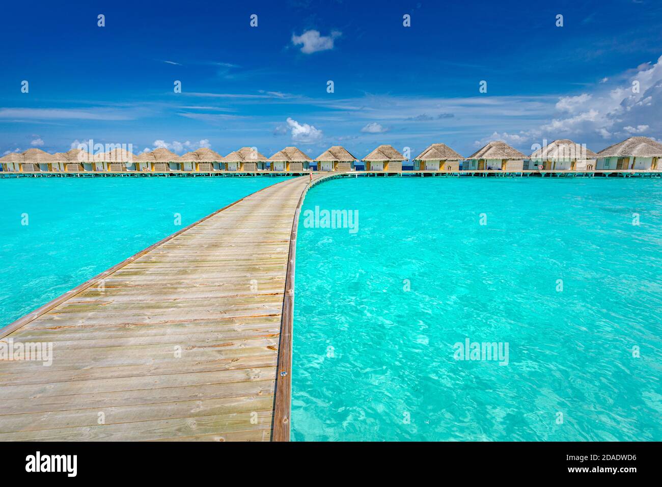 Isola tropicale Maldive con palme da cocco, ponte di legno e villa d'acqua. Paesaggio esotico da viaggio. Bella estate isola paradiso, tranquilla Foto Stock