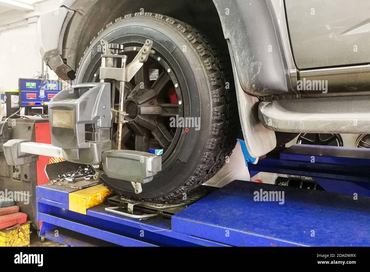 L'auto 4WD viene sottoposta all'allineamento delle ruote in garage Foto Stock