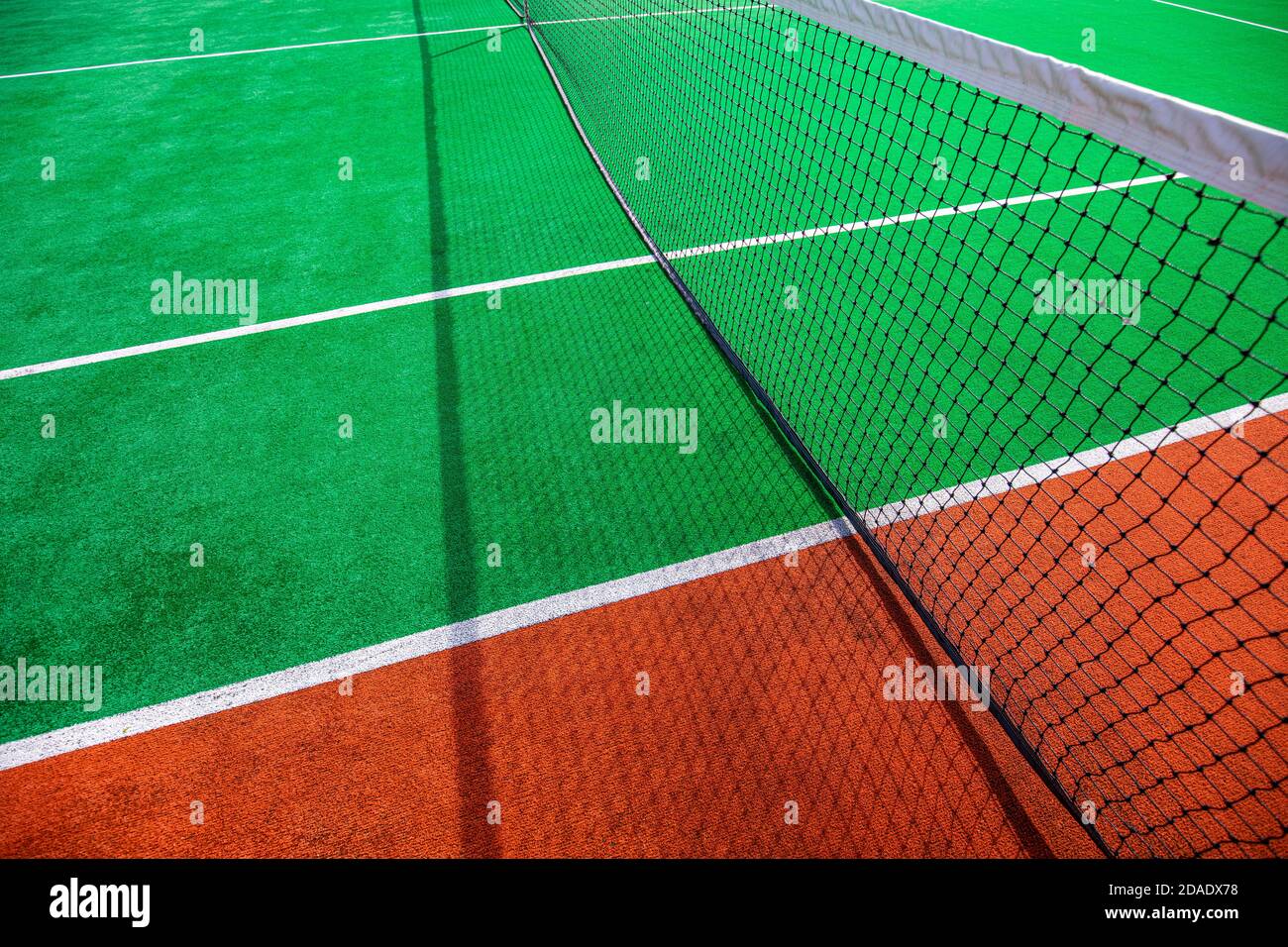 Campo da tennis in terra battuta. Campi da tennis che fanno un motivo interessante. Astratto estate sport all'aperto, sfondo ricreativo, campo da tennis in una giornata di sole Foto Stock