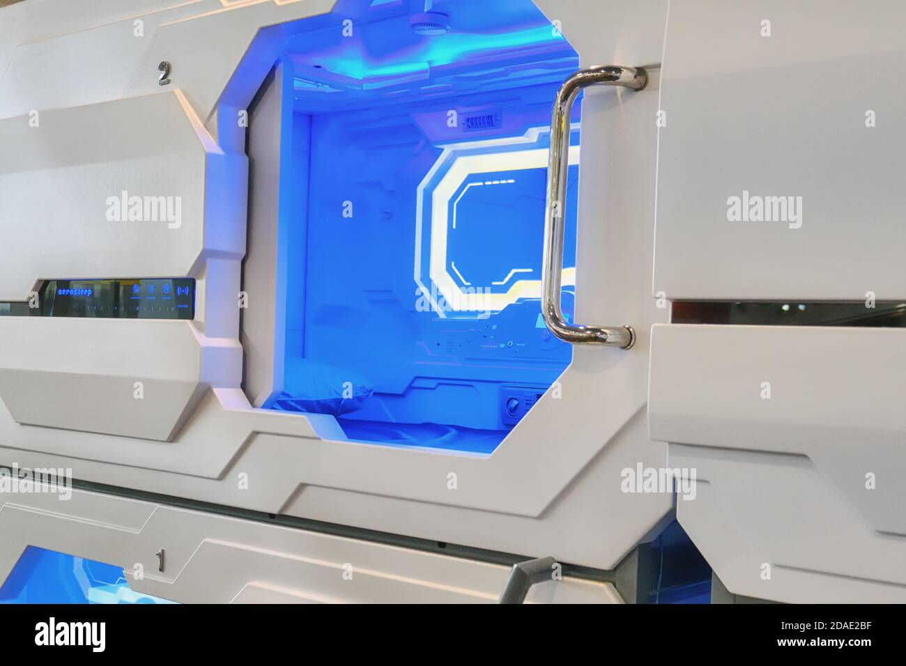 Un posto per il viaggiatore per riposare prima del volo Aerosleep hotel. Luce blu all'interno della camera in capsule Hotel - Sheremetievo aeroporto, Mosca / Russi Foto Stock