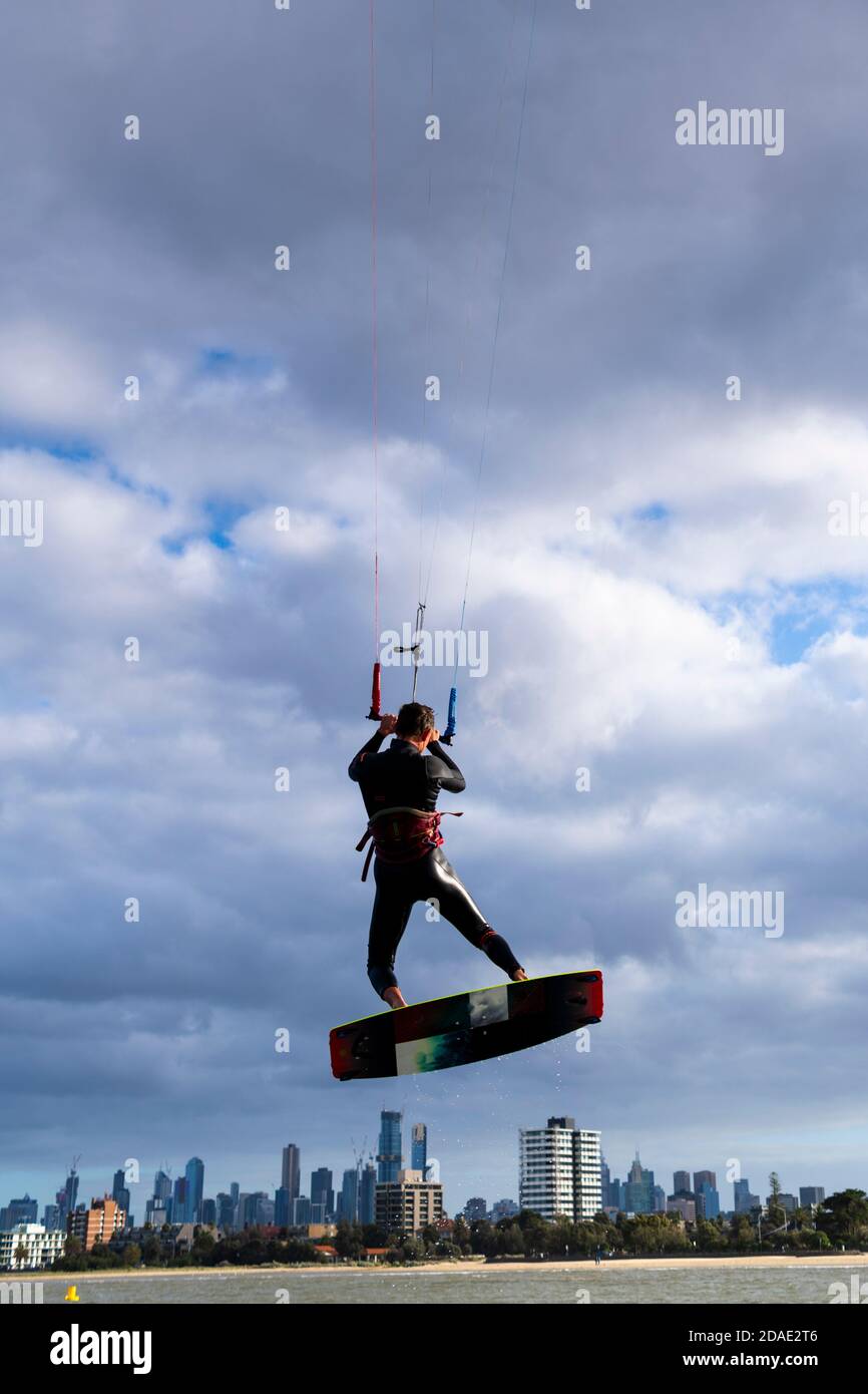 Un kite surfer è alzato nell'aria con il CBD di Melbourne sullo sfondo. Foto Stock