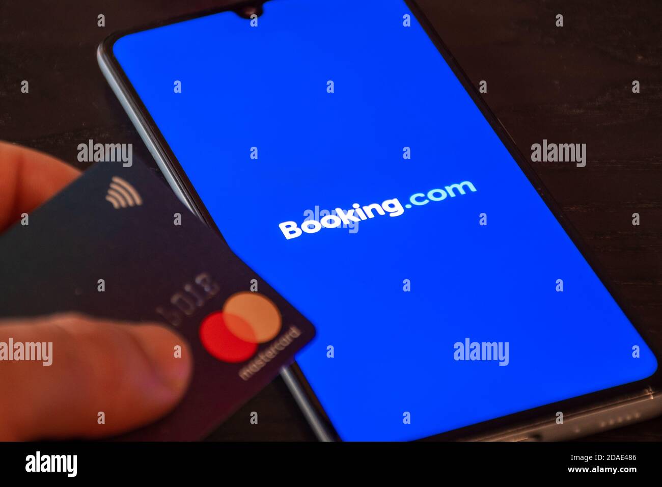 Logo Booking.com visualizzato sullo smartphone con carta di credito, viaggi e crisi del settore alberghiero a causa della pandemia di Covid o Coronavirus, violazione dei dati Foto Stock