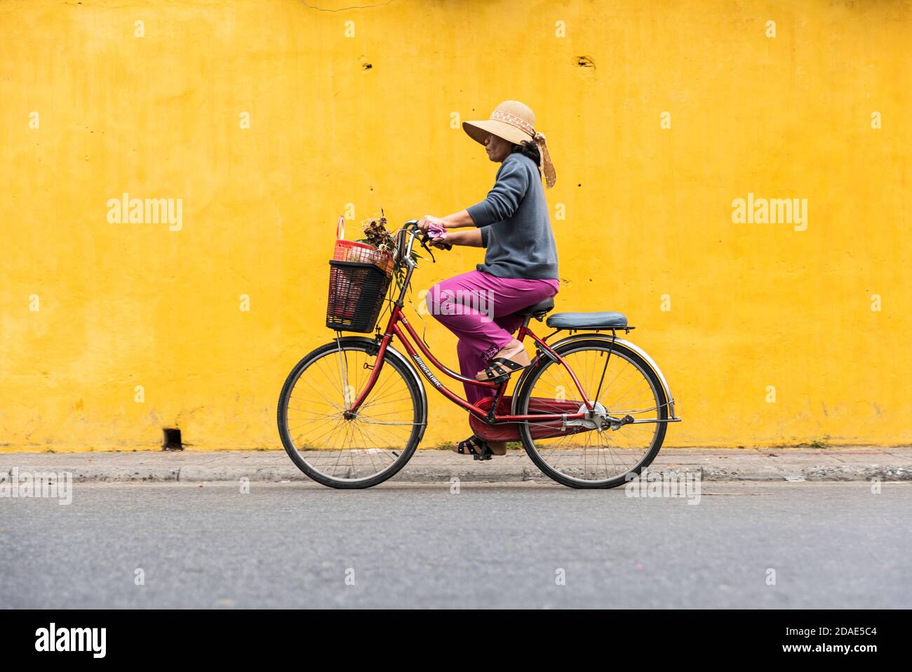 Hoi An Ancient Town, Vietnam, 27 gennaio 2020 - Donna in bicicletta senza casco in una strada a Hoi An Ancient Town Foto Stock