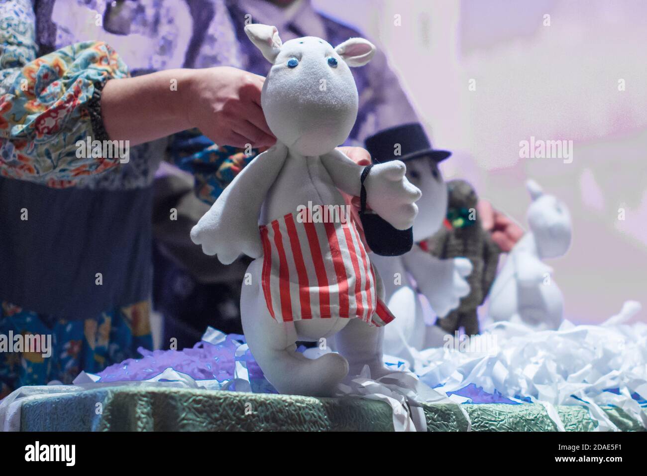 Regione di Mosca / Russia - 01 06 2019: Mano di una donna che tiene una bambola Moomin Troll. L'attore gestisce un burattino ad un'esibizione in teatro. Foto Stock