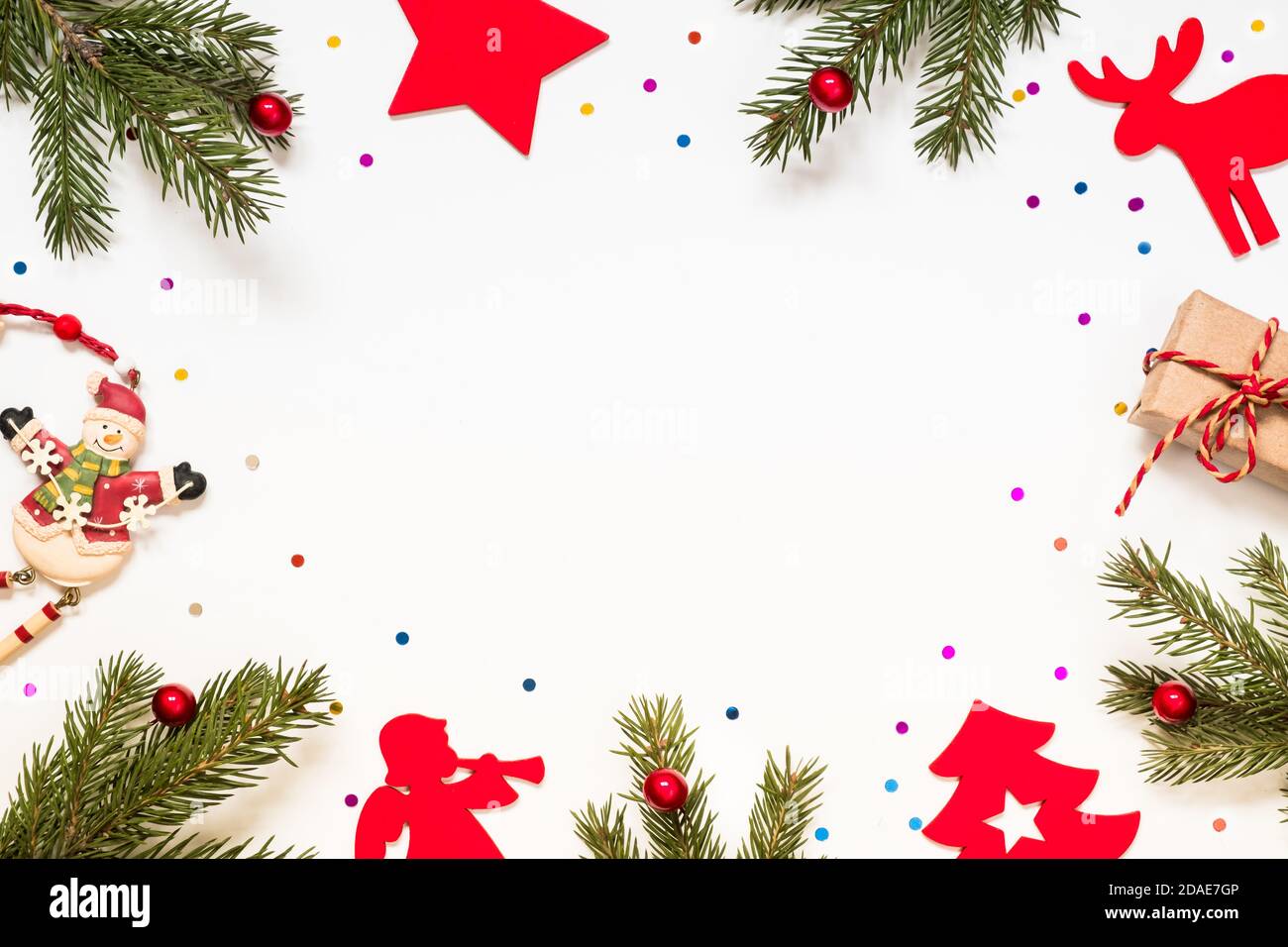 Composizione con rami di un albero di natale e decorazioni natalizie su sfondo bianco. Foto Stock