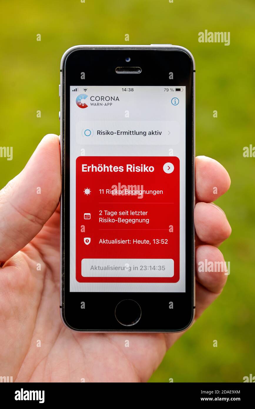 Germania - viene visualizzato il telefono cellulare con l'app di avviso corona aperta aumento del rischio con 11 incontri di rischio Foto Stock