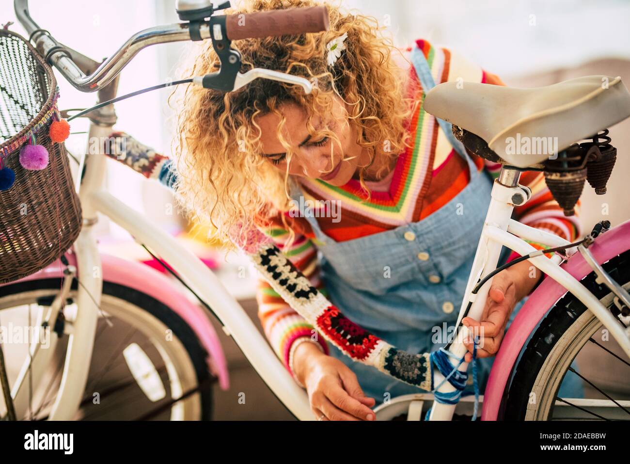 Donna adulta felice a casa in attività di svago di lavoro hobby modifica interna una moto femminile con pezzi di coperture e. pieno di colori - concetto di creatività e bicicletta hippy boho creazione - persone che godono di lavoro artistico a casa Foto Stock