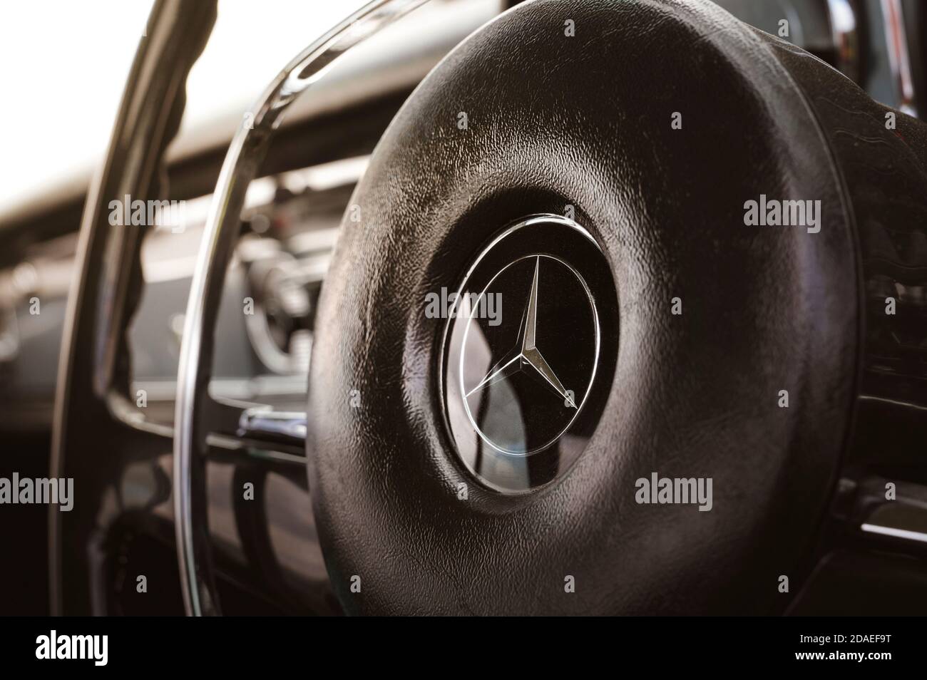 Primo piano sul volante di una classica Mercedes-Benz. Foto Stock
