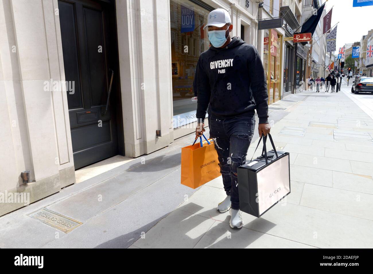Londra, Inghilterra, Regno Unito. Shopping nel West End durante la pandemia COVID, agosto 2020. Uomo che indossa jeans strappati e lacerati con etichetta di design Foto Stock