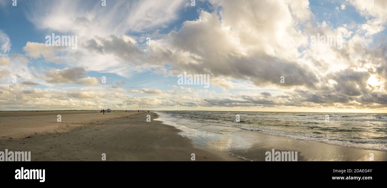 Spiaggia di sabbia con cielo blu e spettacolari nuvole sul lungomare della costa in morbida luce del tramonto. Romo Bilstrand, Lakolk Strand, Mare del Nord, Danimarca. Foto Stock