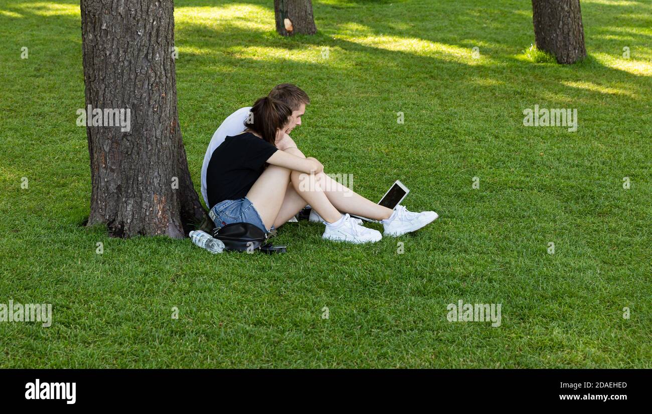 KIEV, UCRAINA - 06 giugno 2019: Volodymyrska Hill o Saint Volodymyr Hill a Kiev. I giovani si riposano sull'erba in un parco. Foto Stock