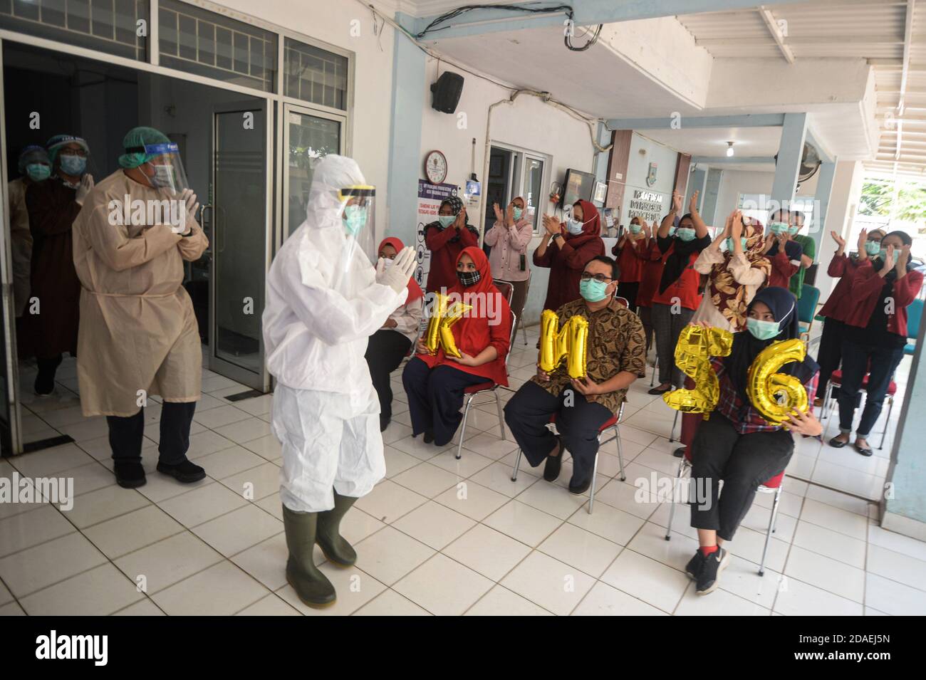 Tangerang meridionale, Indonesia. 12 Nov 2020. Persone che indossano maschere applausi per i medici durante una commemorazione on-line della 56a Giornata Nazionale della Salute presso il centro di salute pubblica di Pondok Betung nel sud Tangerang, Indonesia, 12 novembre 2020. Credit: Agung Kuncahya B./Xinhua/Alamy Live News Foto Stock