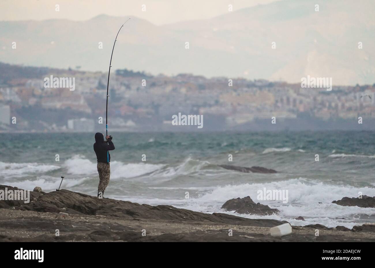 Pescatore in mare, in mare mosso, Spagna. Foto Stock