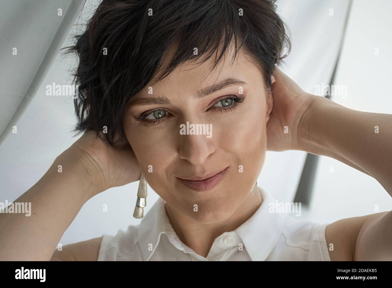 Primo piano tenero ritratto di un volto femminile, bruna dai capelli corti Foto Stock