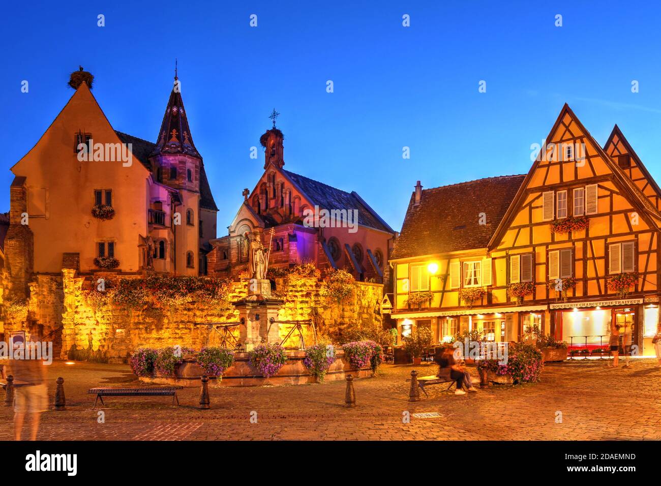 Scena notturna in Piazza Staint Leon, Eguisheim, un villaggio medievale meravigliosamente conservato nella regione vinicola francese dell'Alsazia, con Chateau Saint S Foto Stock