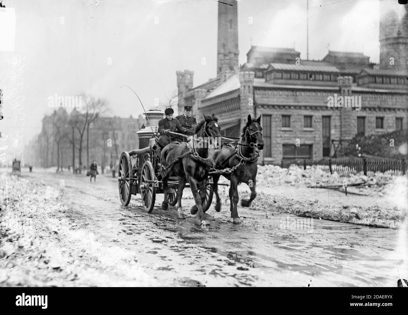 Test del conducente del motore antincendio, uomo che guida un motore antincendio trainato da cavalli di fronte a una stazione dei vigili del fuoco, che si sposta verso la telecamera, Chicago, Illinois. Foto Stock