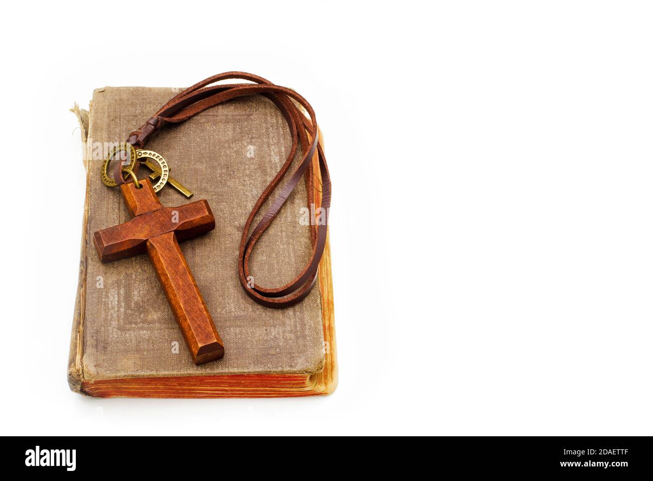 Croce di legno sul libro religioso vecchio e rotto Foto Stock