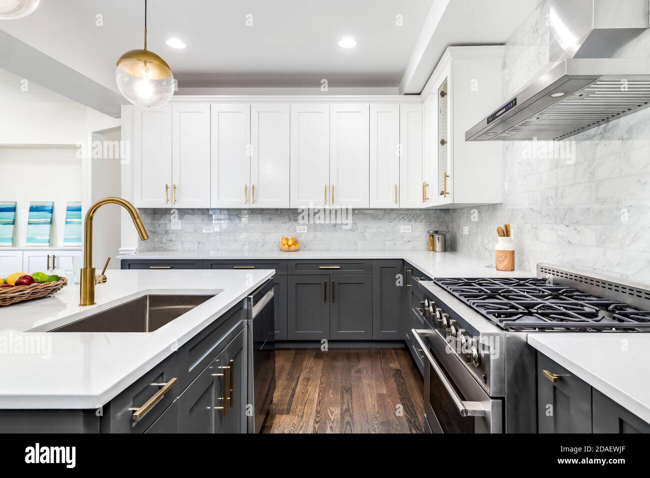 Una lussuosa cucina bianca e grigia con ferramenta dorata, elettrodomestici  in acciaio inossidabile Bosch e Samsung e ripiani in granito marmorizzato  bianco Foto stock - Alamy