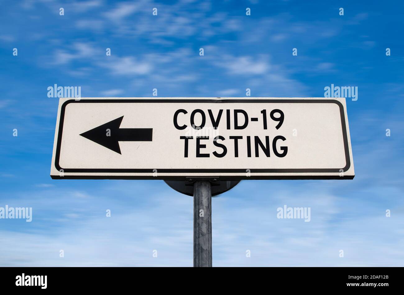COVID-19 segnale stradale di prova, freccia su sfondo blu cielo. Cartello stradale a senso unico vuoto con spazio per la copia. Freccia su un palo che punta in una direzione. Foto Stock