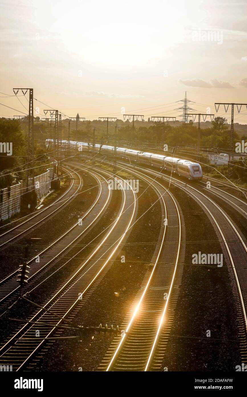 Essen, Ruhrgebiet, Nordrhein-Westfalen, Germania - binari del treno contro la luce del sole serale, IL TRENO ICE va alla stazione centrale. Foto Stock