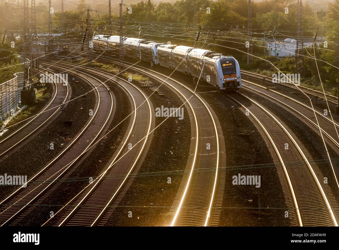 Essen, zona della Ruhr, Renania Settentrionale-Vestfalia, Germania - piste contro la luce del sole serale, treno RRX per Hamm. Foto Stock