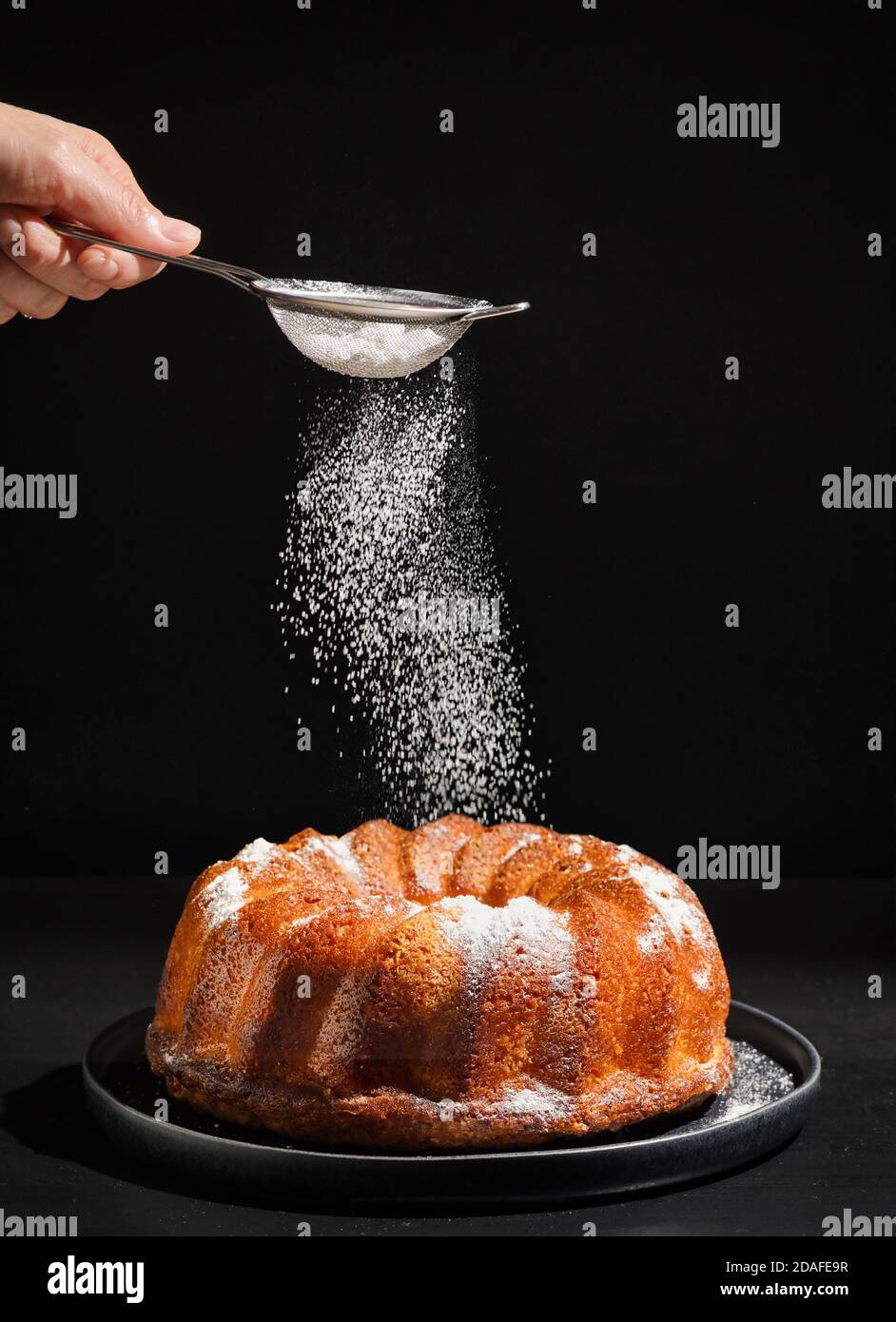 Zucchero in polvere con setaccio sulla torta Gugelhupf Foto Stock