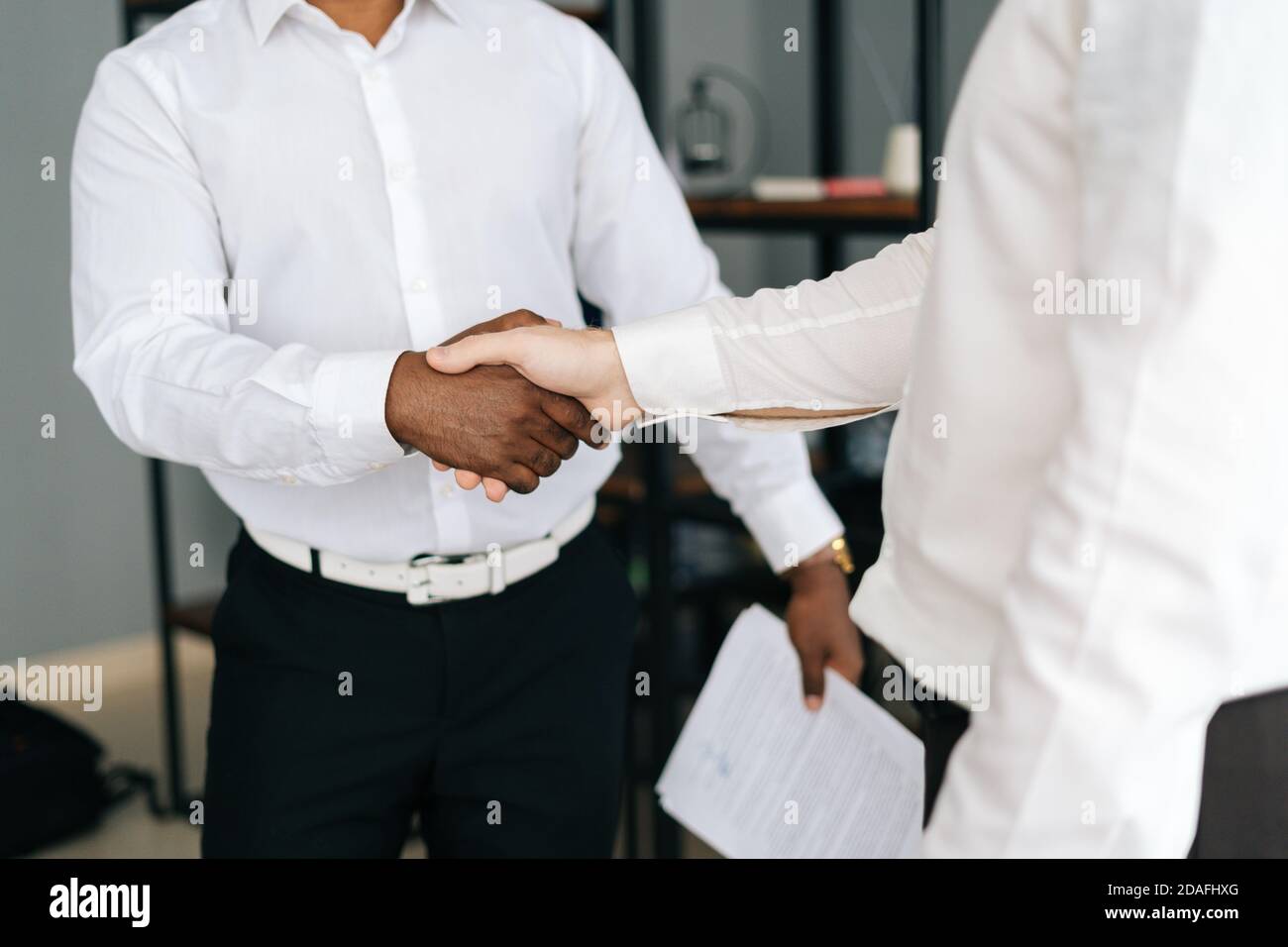 Vista ravvicinata dei diversi partner commerciali che si stanno muovendo con un accordo nella sala degli uffici. Foto Stock