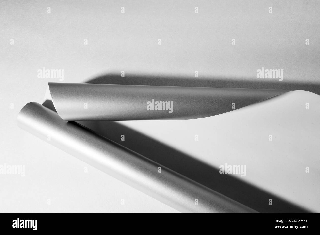 Vista dall'alto della carta in rotoli grigia, sfondo bianco e nero astratto, spazio di copia Foto Stock