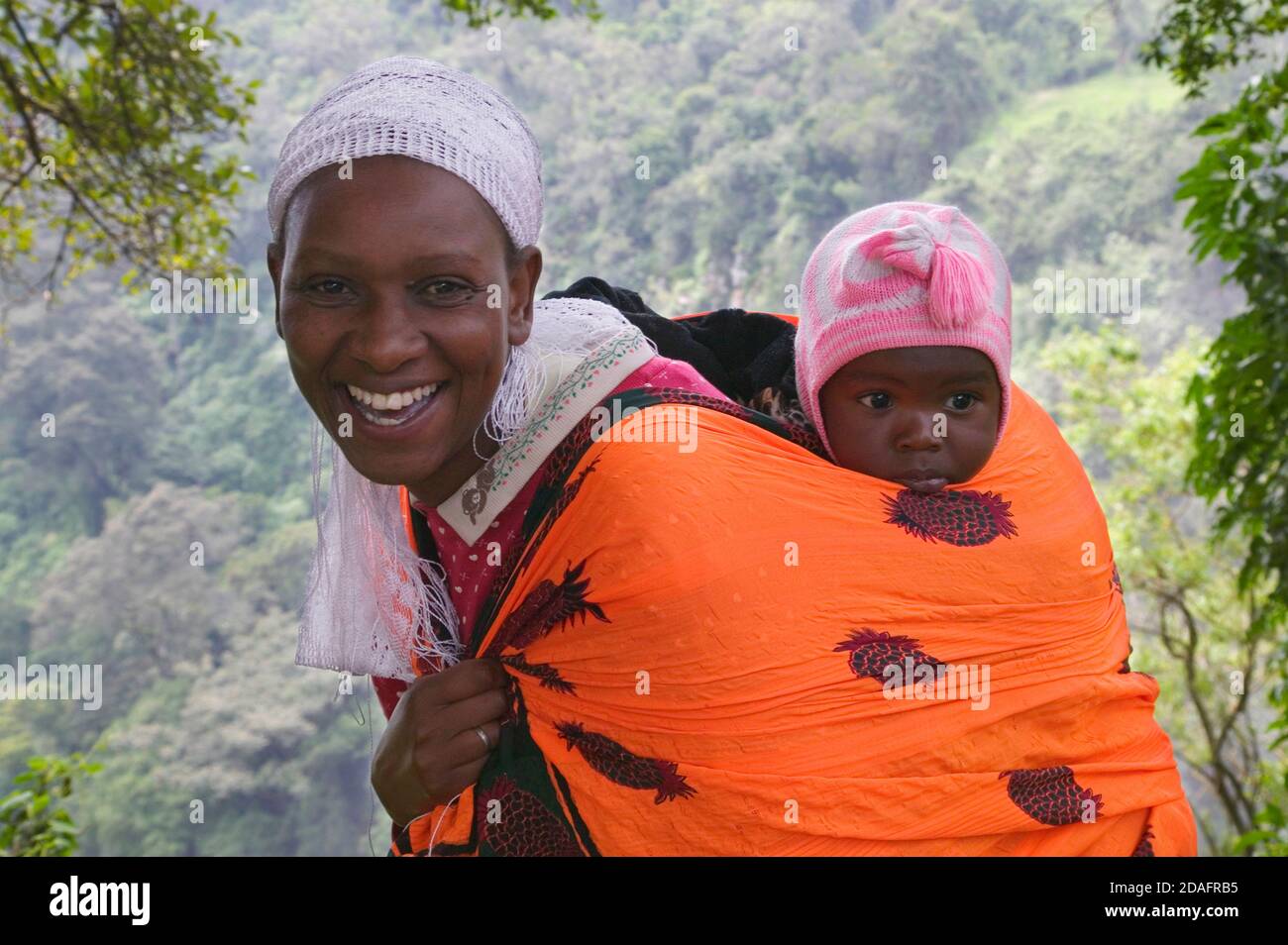 Masai donna che trasporta il bambino, Masai Mara, Kenia Foto Stock