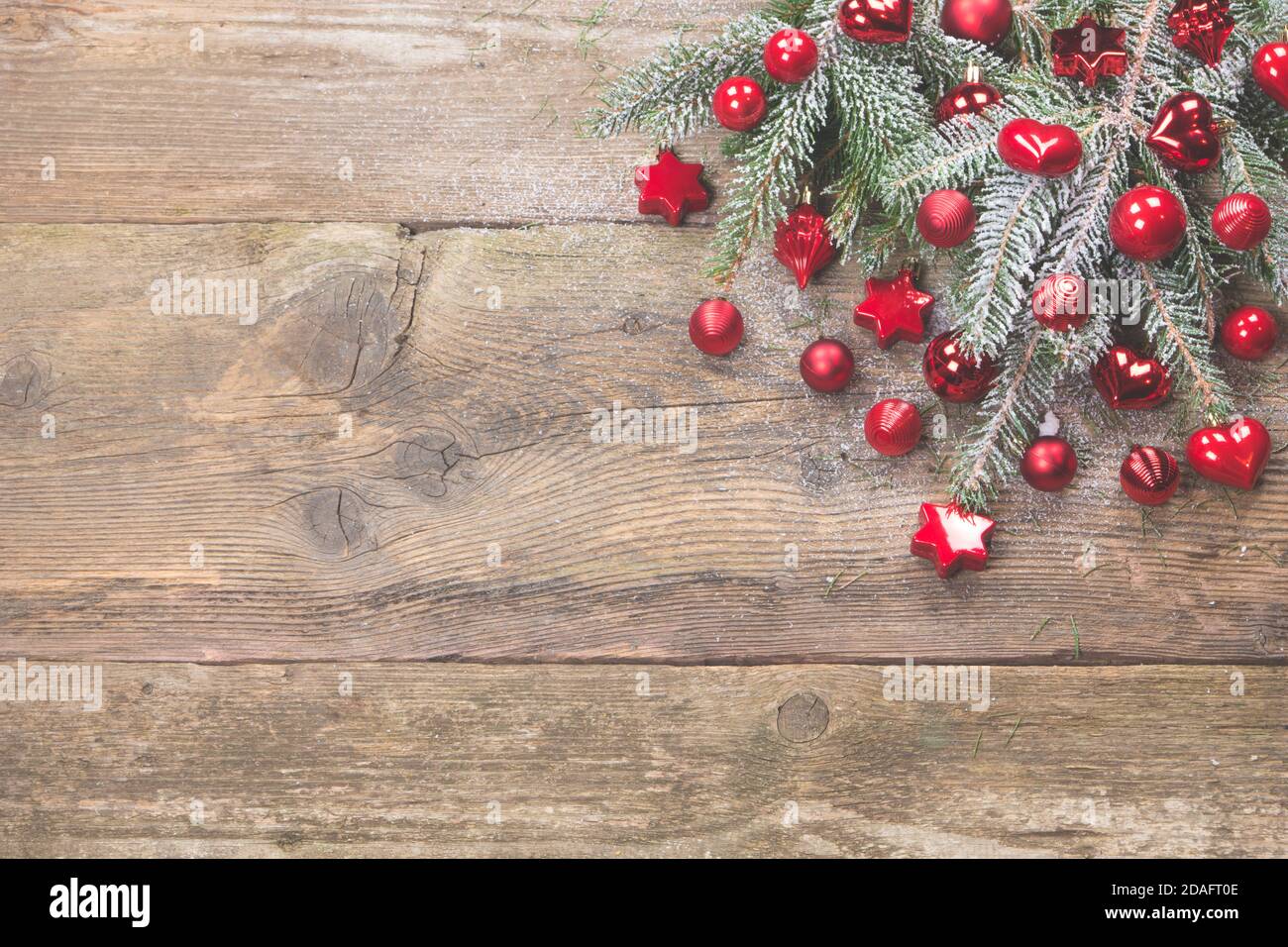 Biglietto d'auguri di Natale o valpapà in decorazione rossa con spazio per fotocopie. Sfondo in legno antico addobbato con aghi nevosi e palline rosse di natale. Foto Stock