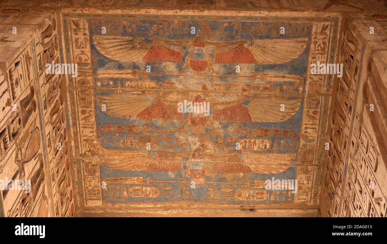 Antiche incisioni egiziane di uccelli aquila e geroglifici sul tetto di un antico tempio. Foto Stock