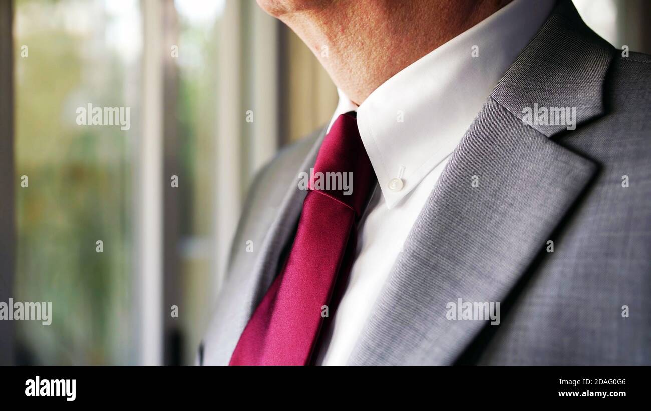 primo piano del collo dell'uomo in un abito da lavoro grigio e cravatta rossa, messa a fuoco selettiva con sfondo copy space. Foto Stock