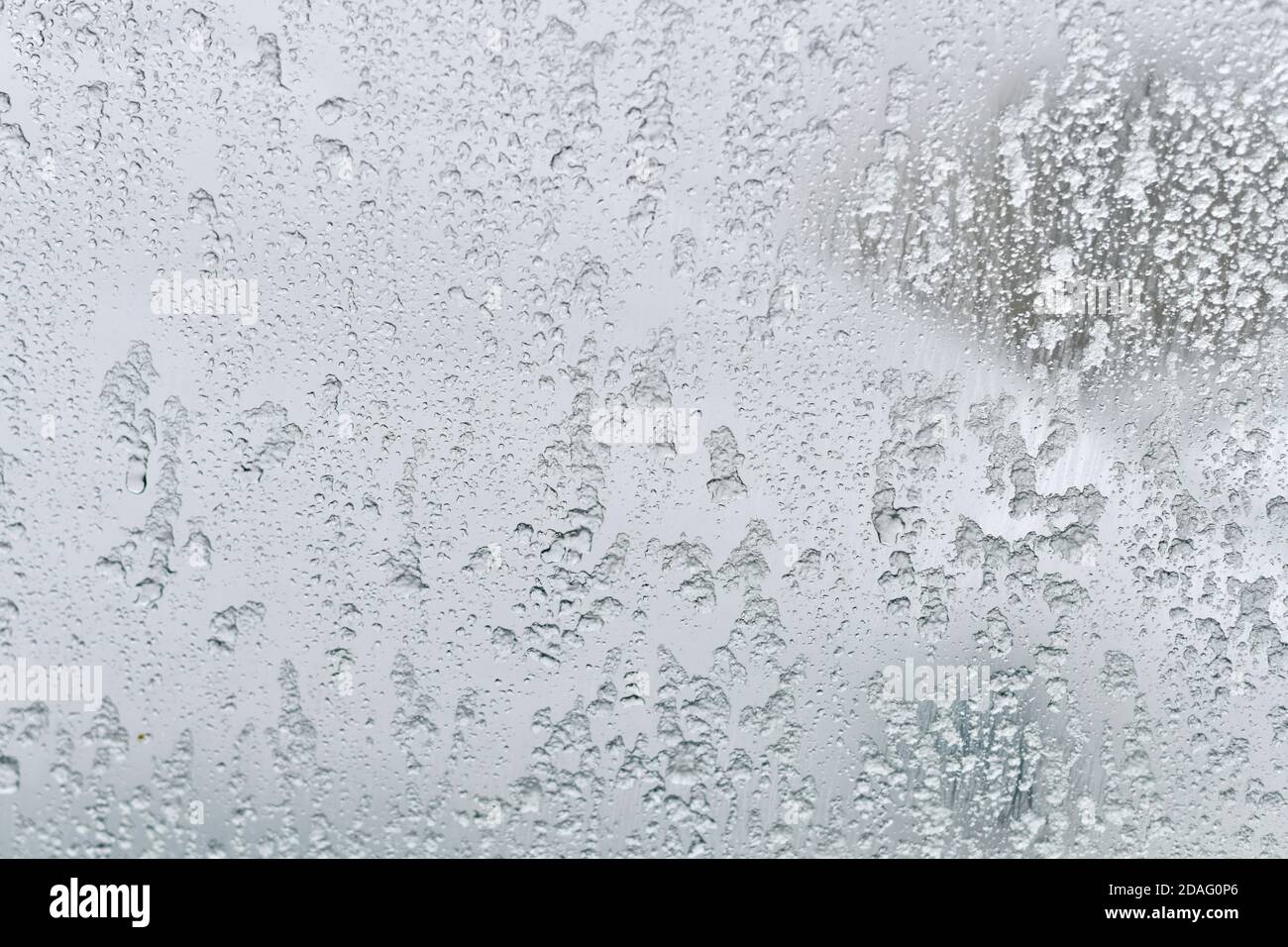 Immagine di sfondo di vetro trasparente glaciale. Il ghiaccio si scioglie e scorre verso il basso. Foto Stock