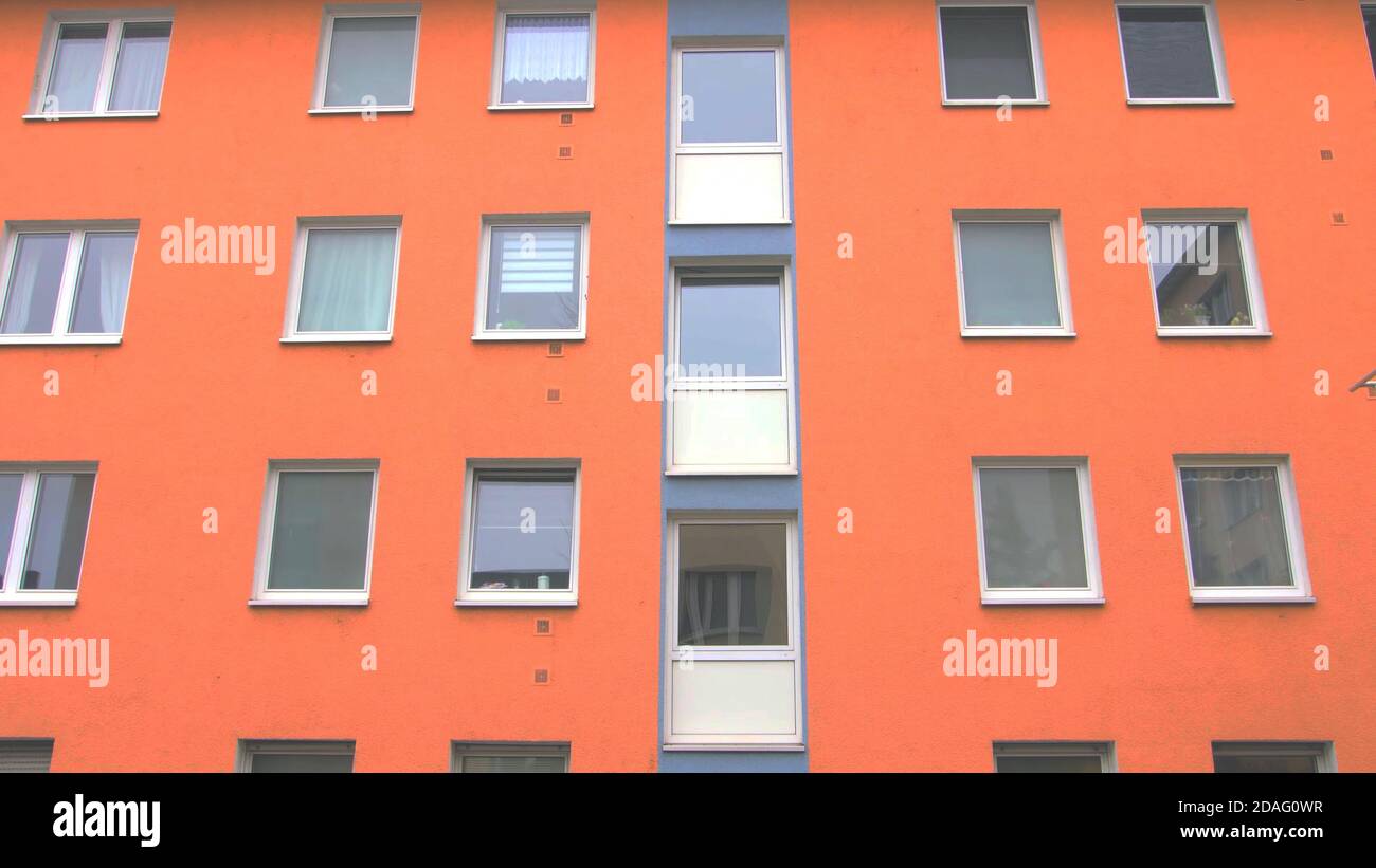edificio dalla colorata facciata arancione con finestre. moderno stile architettonico tedesco europeo. Foto Stock
