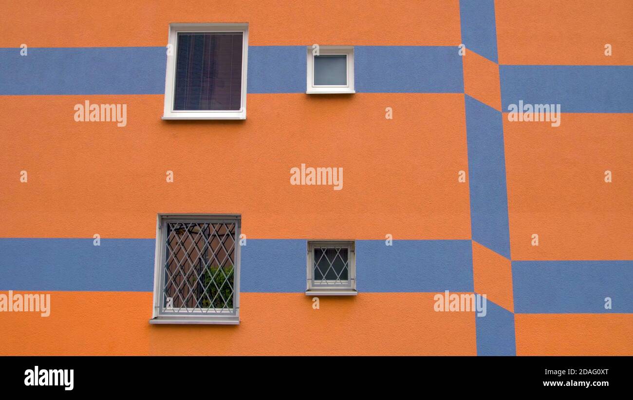 edificio dalla facciata colorata arancione e blu con finestre. moderno stile architettonico tedesco europeo. Foto Stock