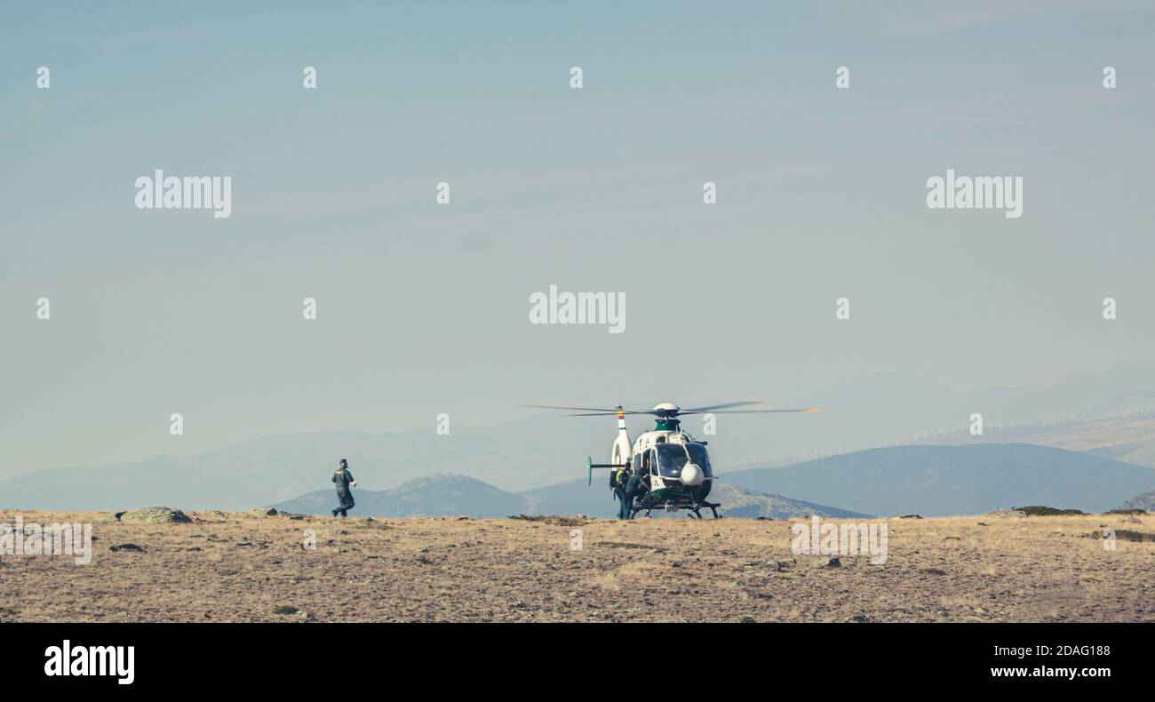 Elicottero di soccorso di montagna, operazione di salvataggio di persone. Manovra pericolosa e rischiosa Foto Stock