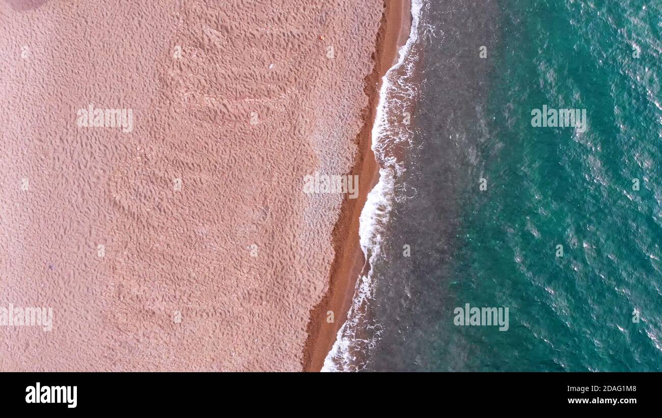 vista dall'alto di una bellissima spiaggia di sabbia e di acque turchesi trasparenti. Foto Stock