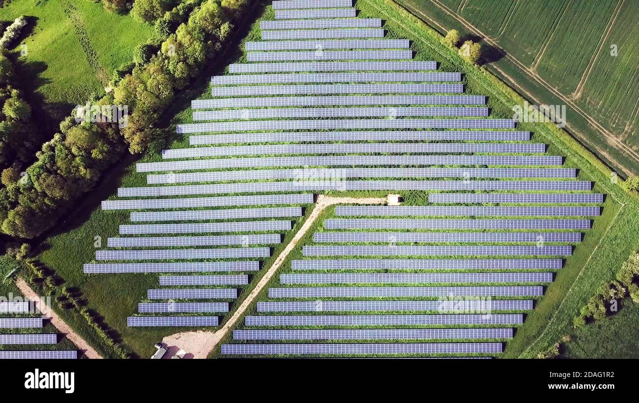 Vista dall'alto dei pannelli solari tra campi verdi, centrale fotovoltaica. Foto Stock