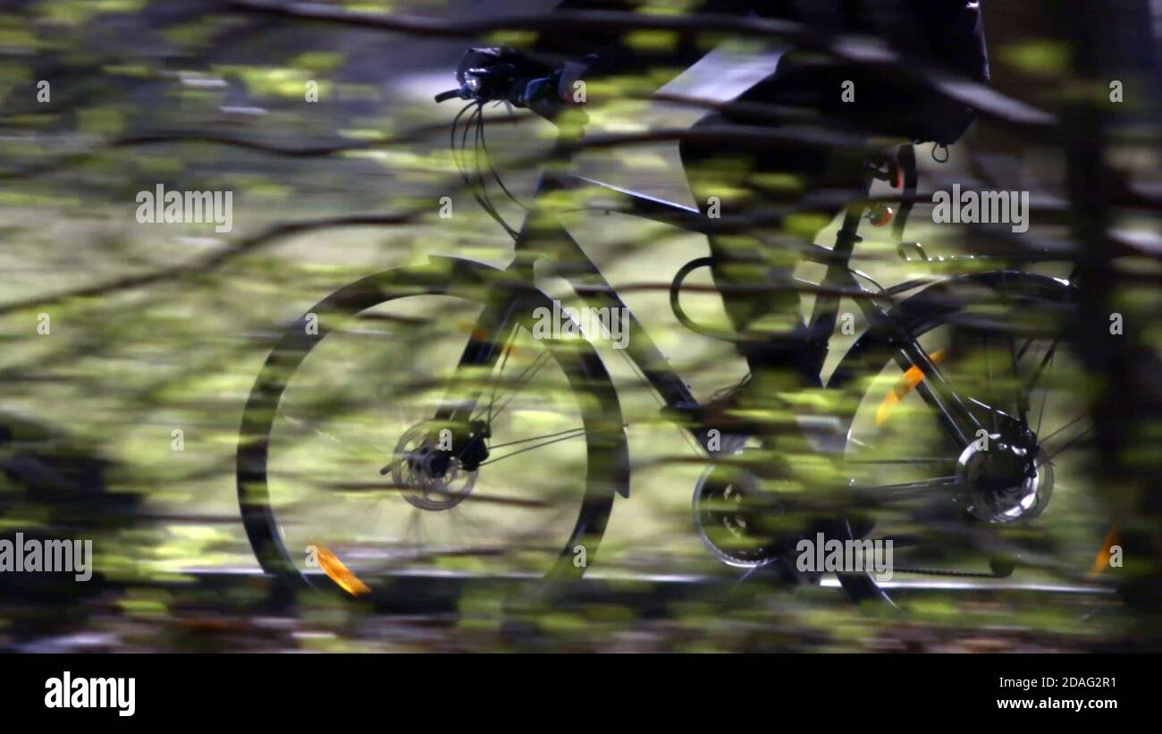 effetto di sfocatura del movimento durante la guida di una bicicletta sullo sfondo del parco. Foto Stock