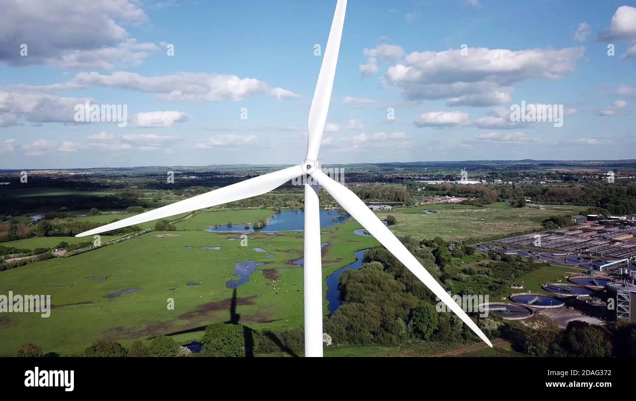 Vista aerea turbina eolica contro area industriale e campi agricoli , produzione di energia. Foto Stock