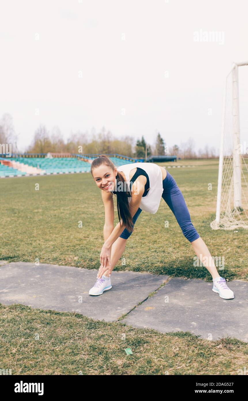 giovane ragazza atletica che fa esercizio si scalda allo stadio Foto Stock