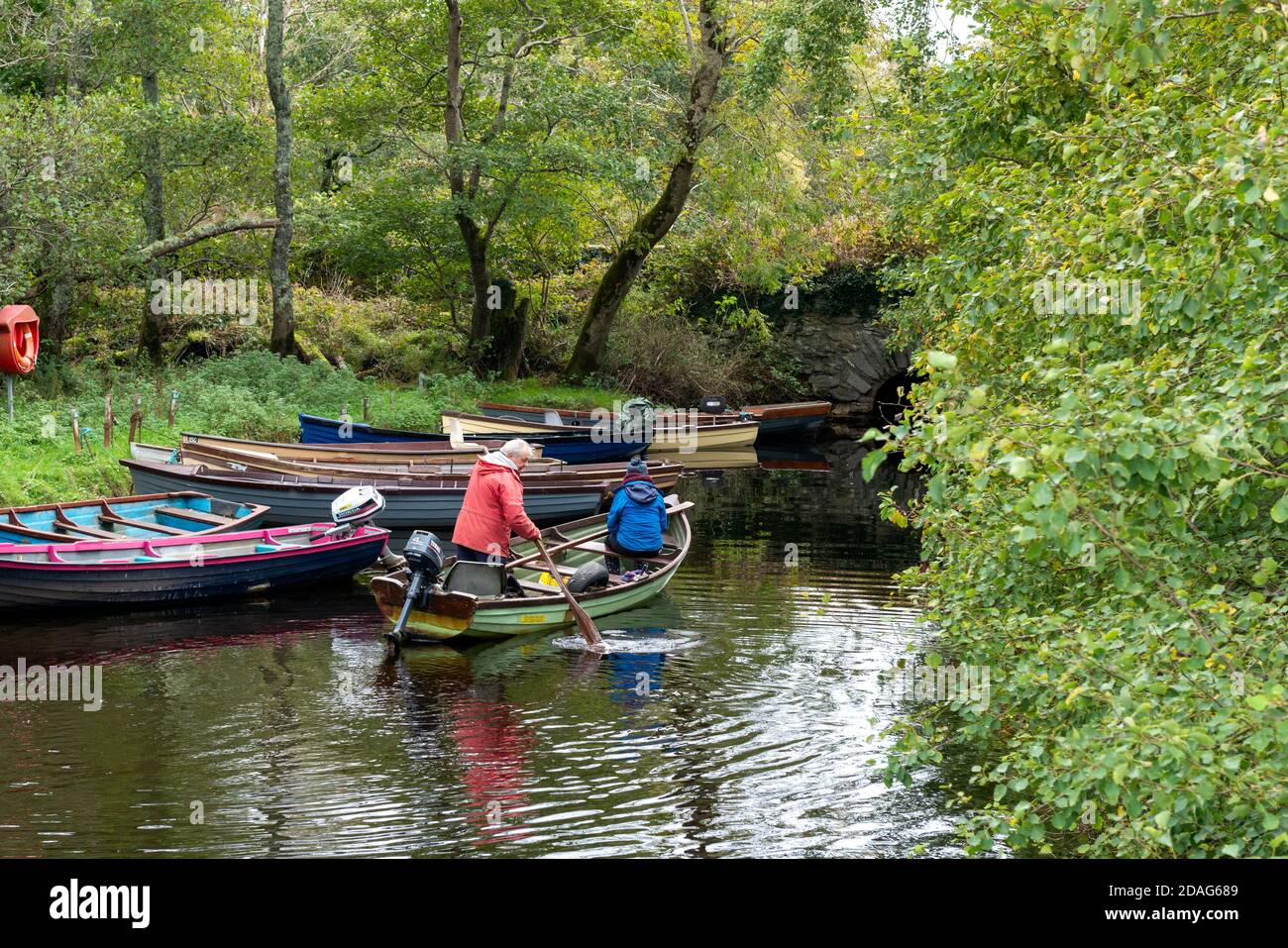 Coppia anziana che si addormeggia su una clinker boat o su una barca a remi da pesca nella piccola insenatura del lago nel Killarney National Park, County Kerry, Irlanda, Europa Foto Stock