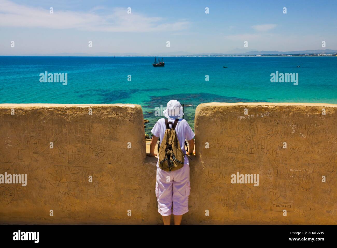 Tourist guardare la barca in mare dal fort, Hammamet, Tunisia Foto Stock