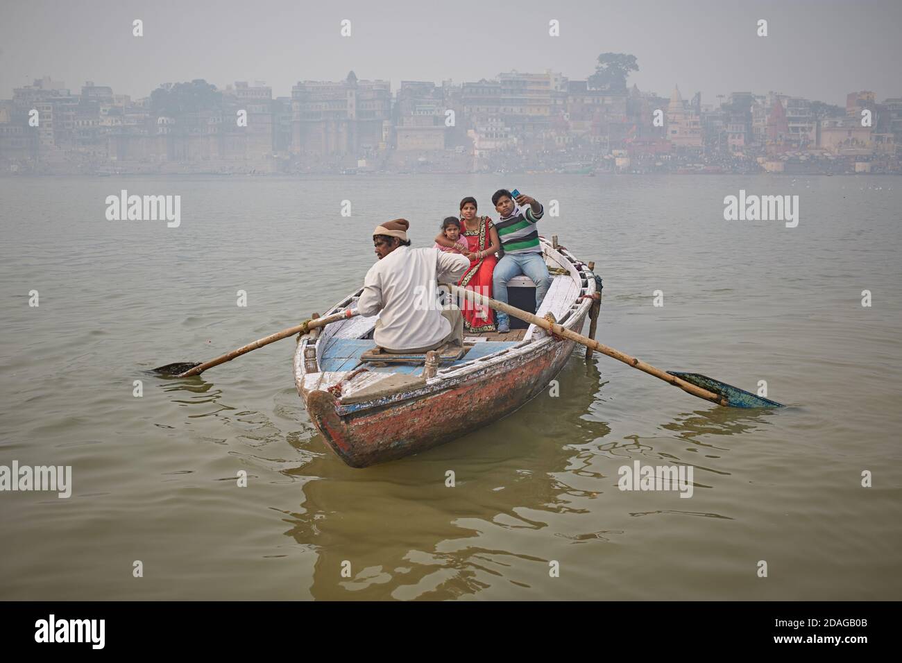 Varanasi, India, gennaio 2016. Una famiglia in una barca nella nebbia che naviga sul fiume Gange. Foto Stock