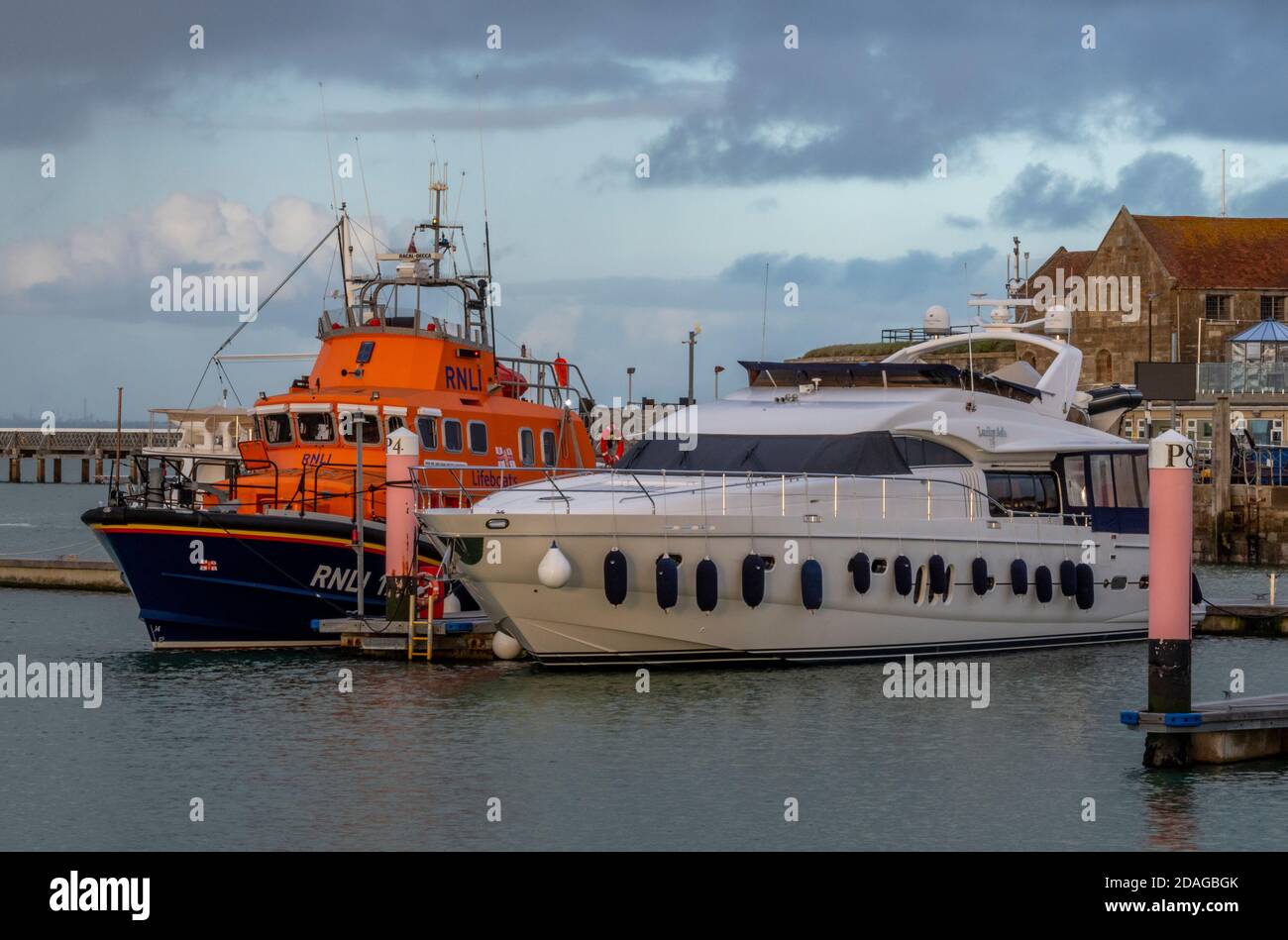 La linfa di yarmouth sull'isola di wight accanto a un lussuoso motoscafo o yacht a motore in una serata autunnale alla luce atmosferica. Foto Stock