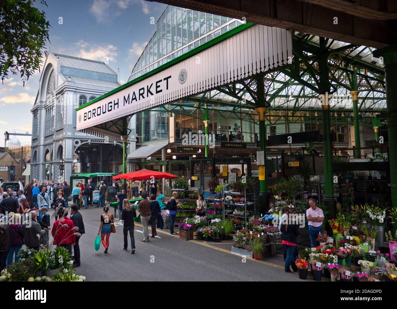 Borough Market Entrance Mostra prodotti esterni e bancarelle di fiori al tramonto un rinomato mercato internazionale di prodotti alimentari affollato mercato al dettaglio al tramonto London Bridge Southwark Londra UK Foto Stock