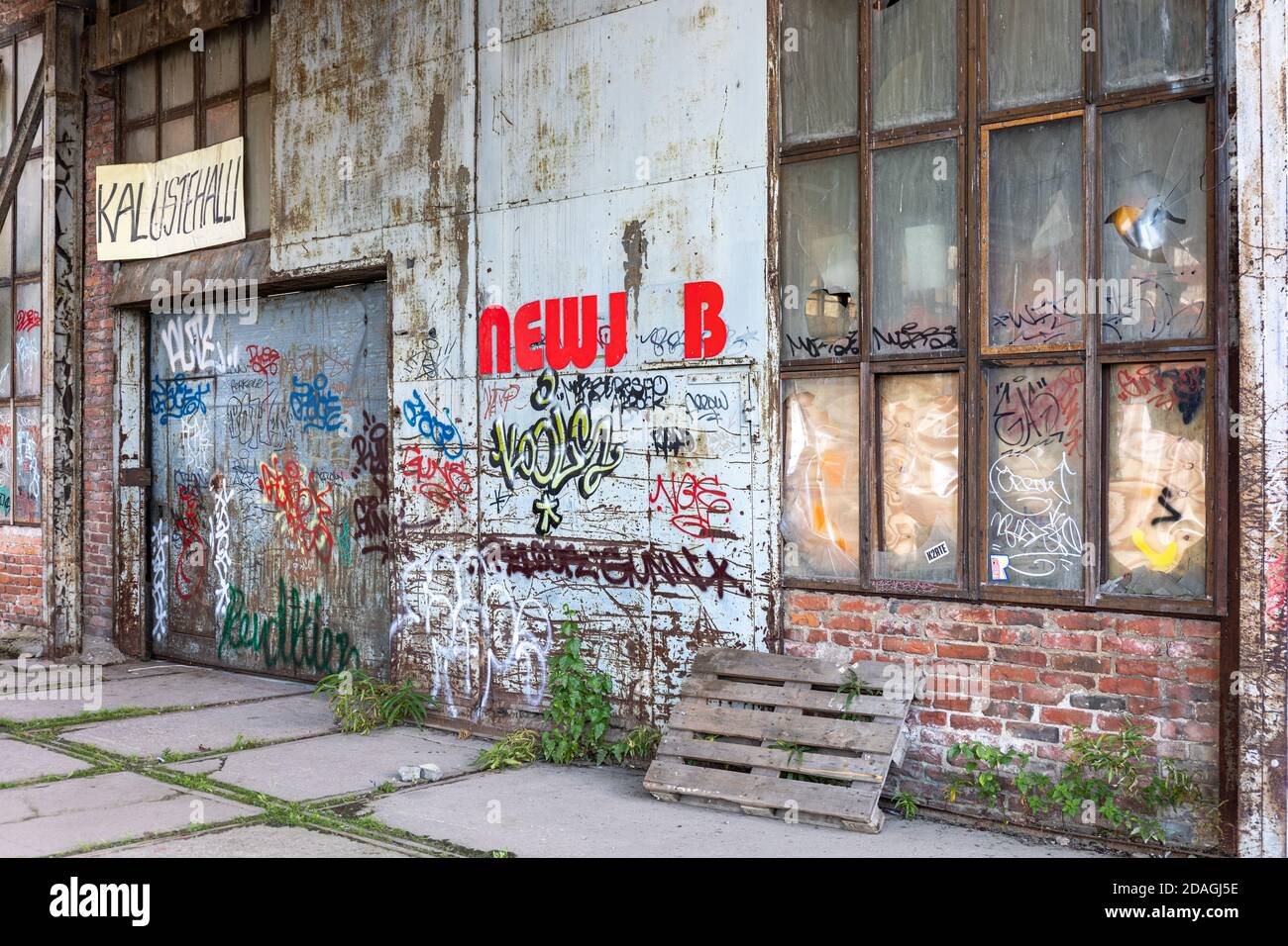 Vecchio edificio industriale con graffiti e tag nel quartiere Konepaja di Helsinki, Finlandia Foto Stock