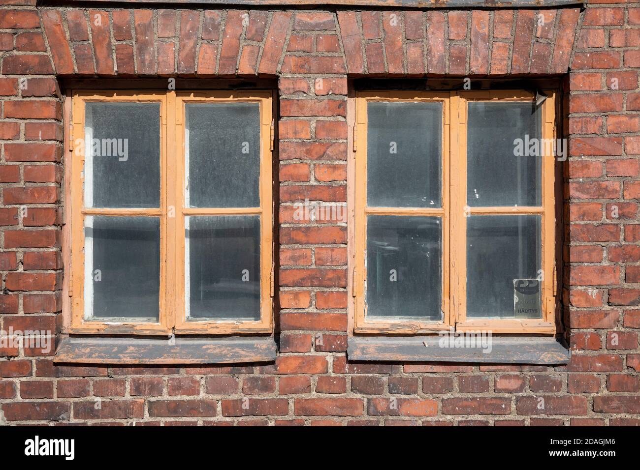 Vecchie finestre industriali in mattoni rossi nel quartiere Konepaja di Helsinki, Finlandia Foto Stock